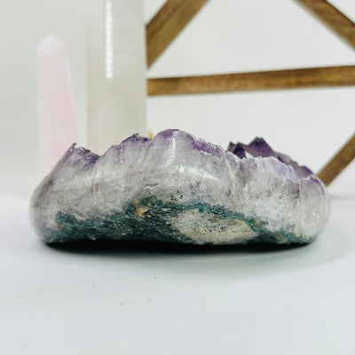 amethyst crystal heart with decorations in the background
