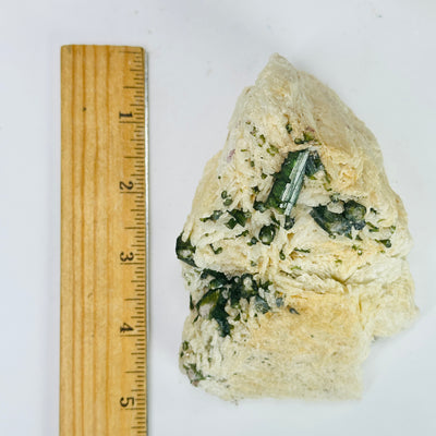 tourmaline on matrix next to a ruler for size reference