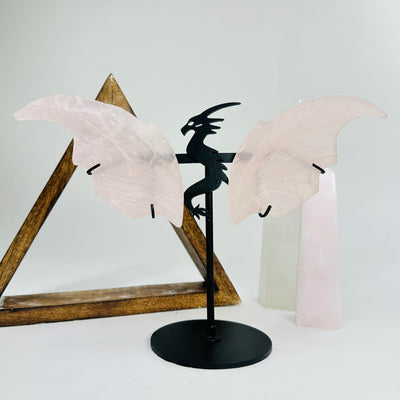 rose quartz dragon on metal stand with decorations in the background