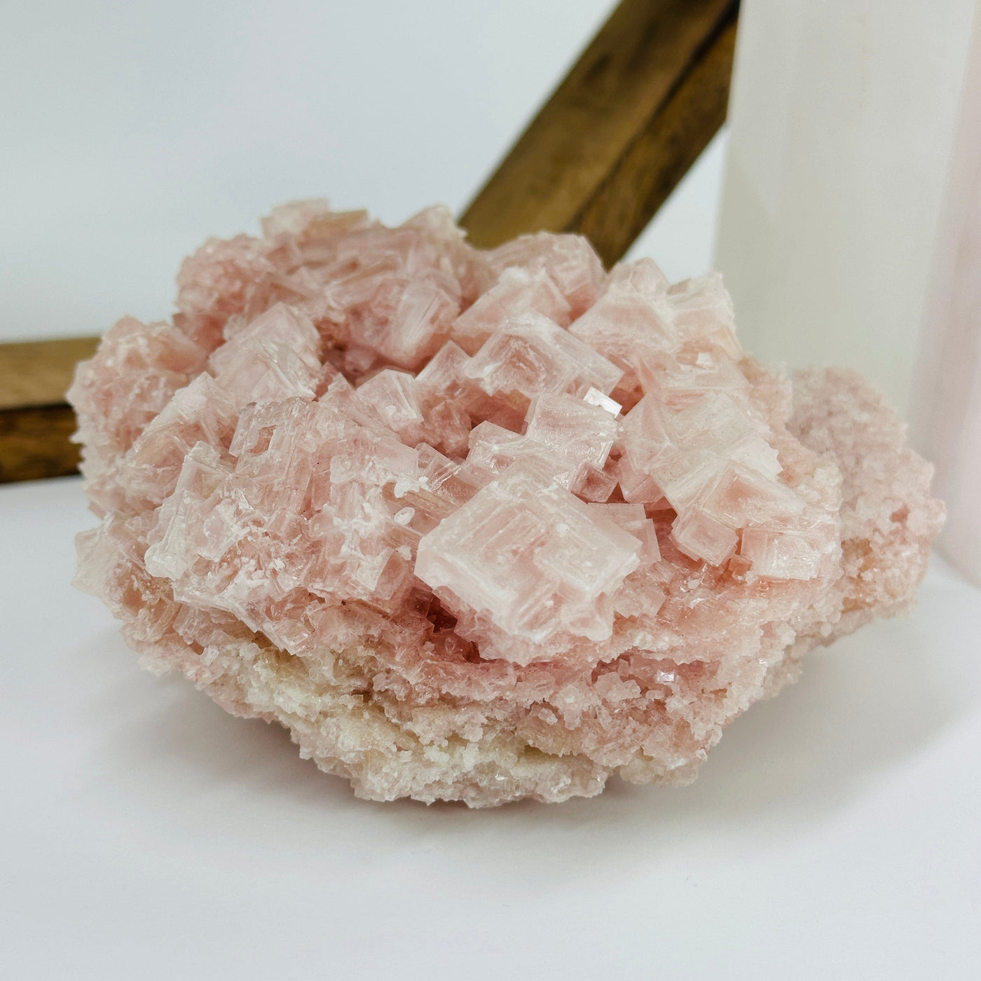 Pink halite cluster with decorations in the background