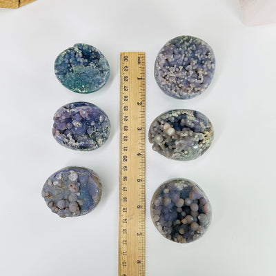 Grape agate cluster next to a ruler