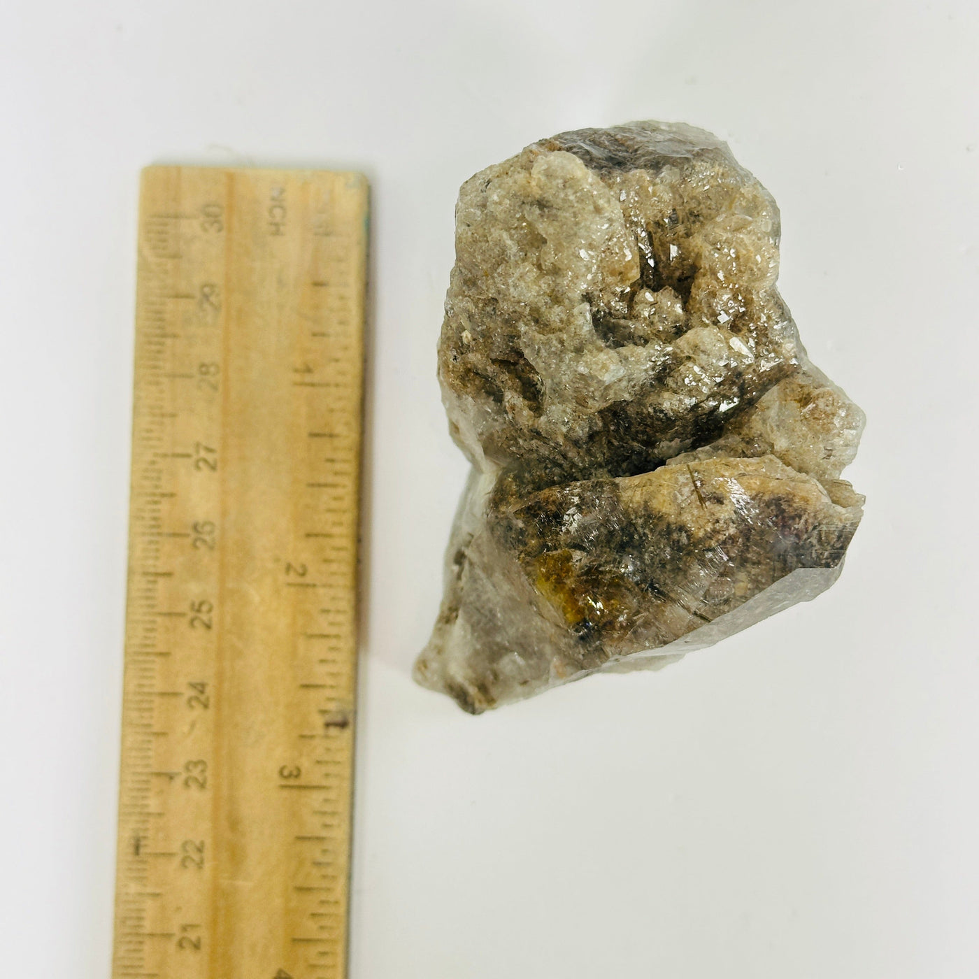 rutile quartz next to a ruler for size reference