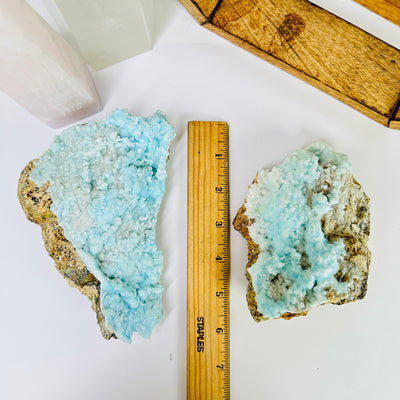 blue aragonite next to a ruler for size reference