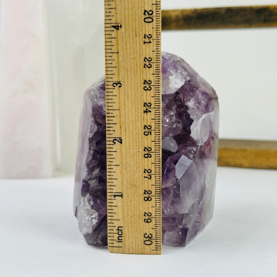 amethyst point next to a ruler for size reference