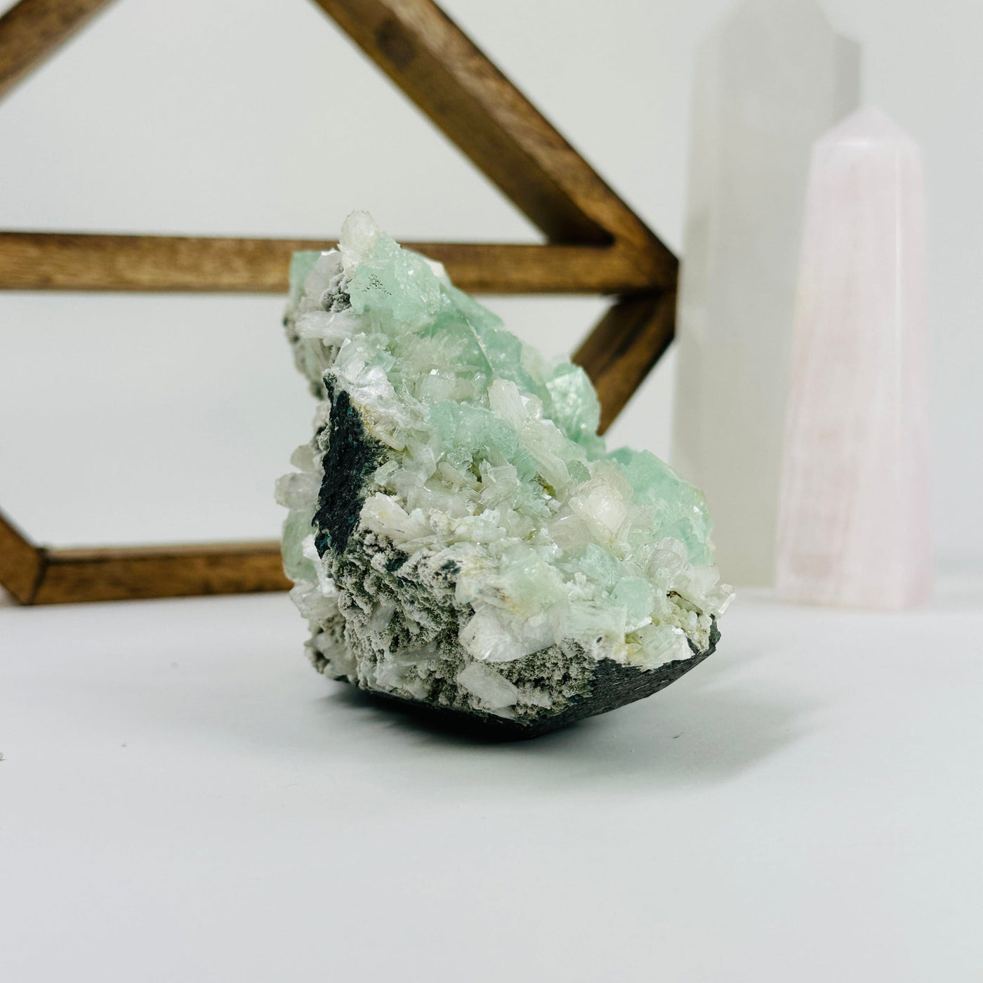 green apophyllite with decorations in the background