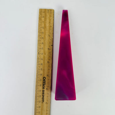 pink agate point next to a ruler for size reference