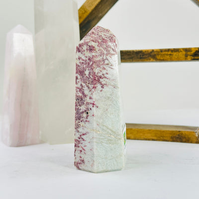 pink tourmaline point with decorations in the background