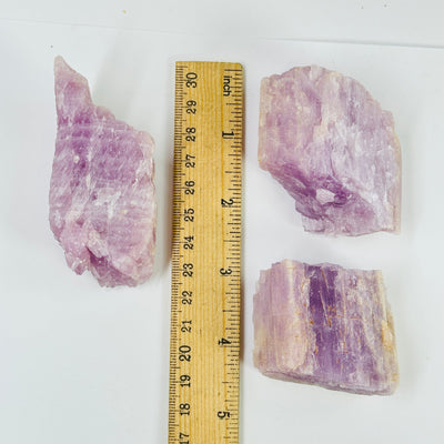 kunzite next to a ruler for size reference