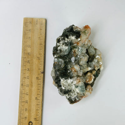 zeolite with stilbite next to a ruler for size reference