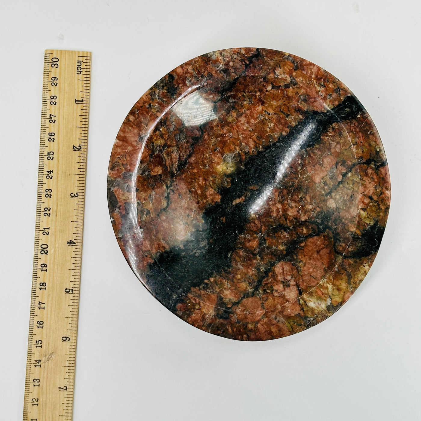 feldspar and tourmaline bowl next to a ruler for size reference