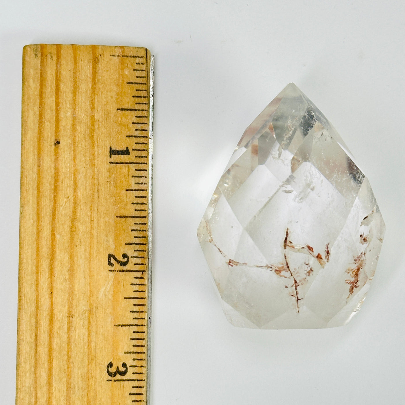 crystal quartz point next to a ruler for size reference