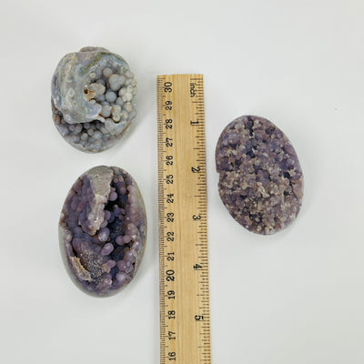 Grape agates next to a ruler for size reference