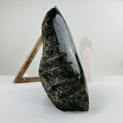 labradorite semi polished cut base with decorations in the background