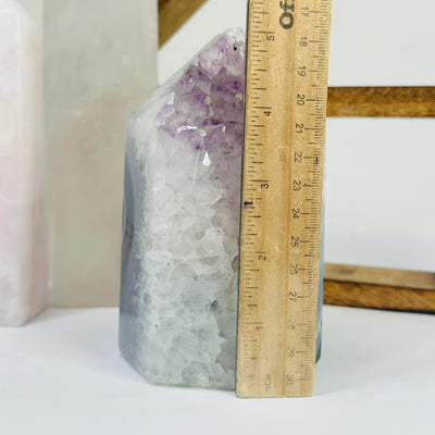 amethyst point next to a ruler for size reference