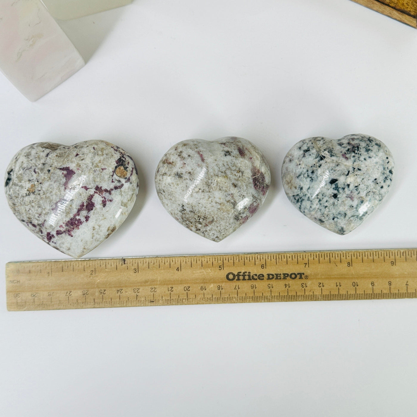 pink tourmaline heart next to a ruler for size reference