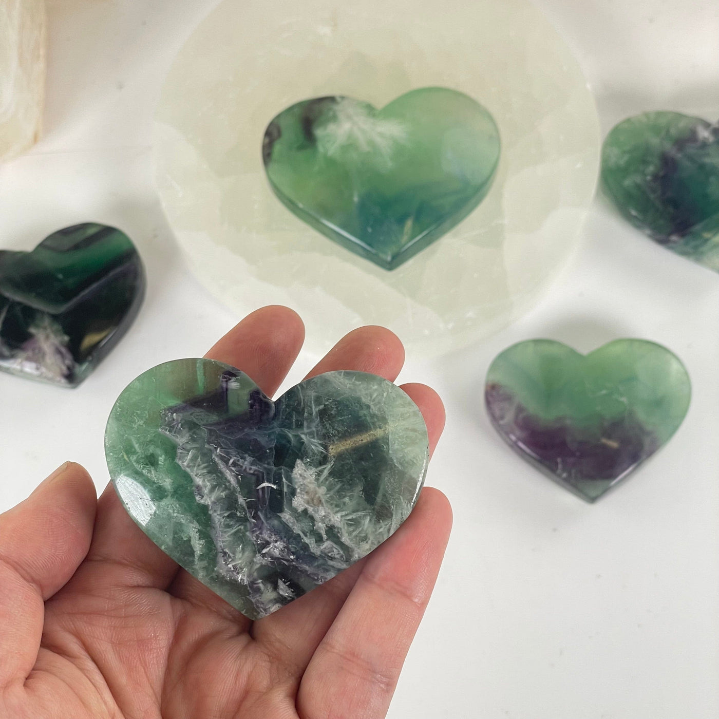 Rainbow Feathered Fluorite Crystal Heart - You Choose one in hand for size reference with others in the background