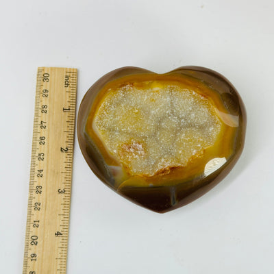 agate heart next to a ruler for size reference