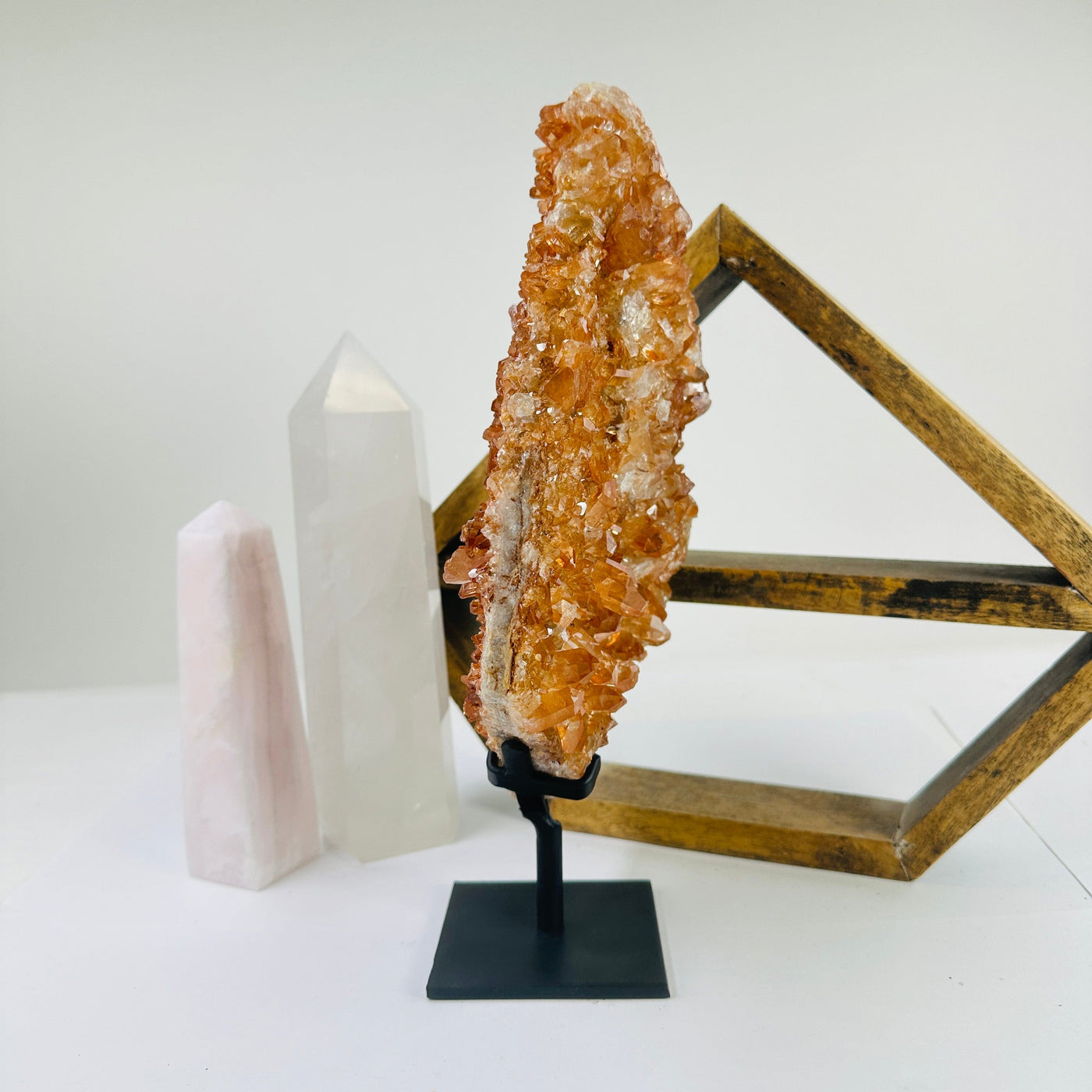 tangerine quartz on stand with decorations in the background