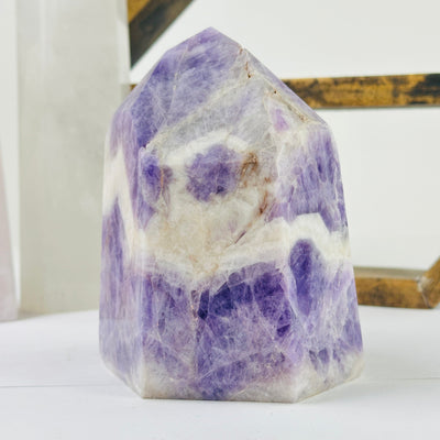 chevron amethyst polished point with decorations in the background