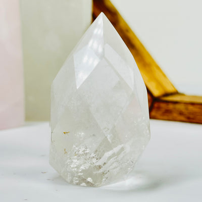 crystal quartz point with decorations in the background