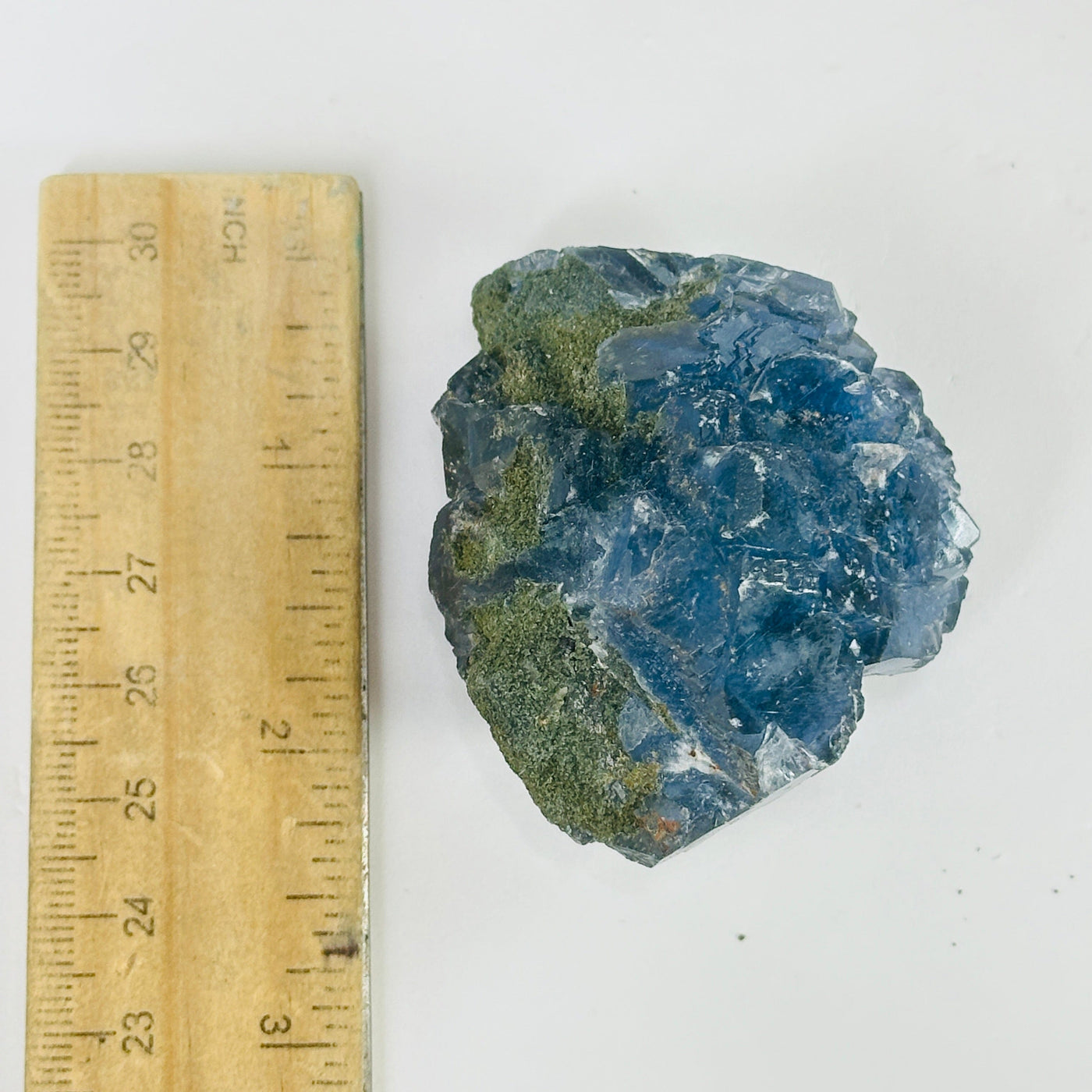 Blue fluorite crystal next to a ruler for size reference