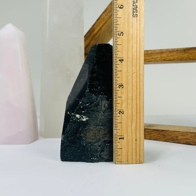 tourmaline point next to a ruler for size reference