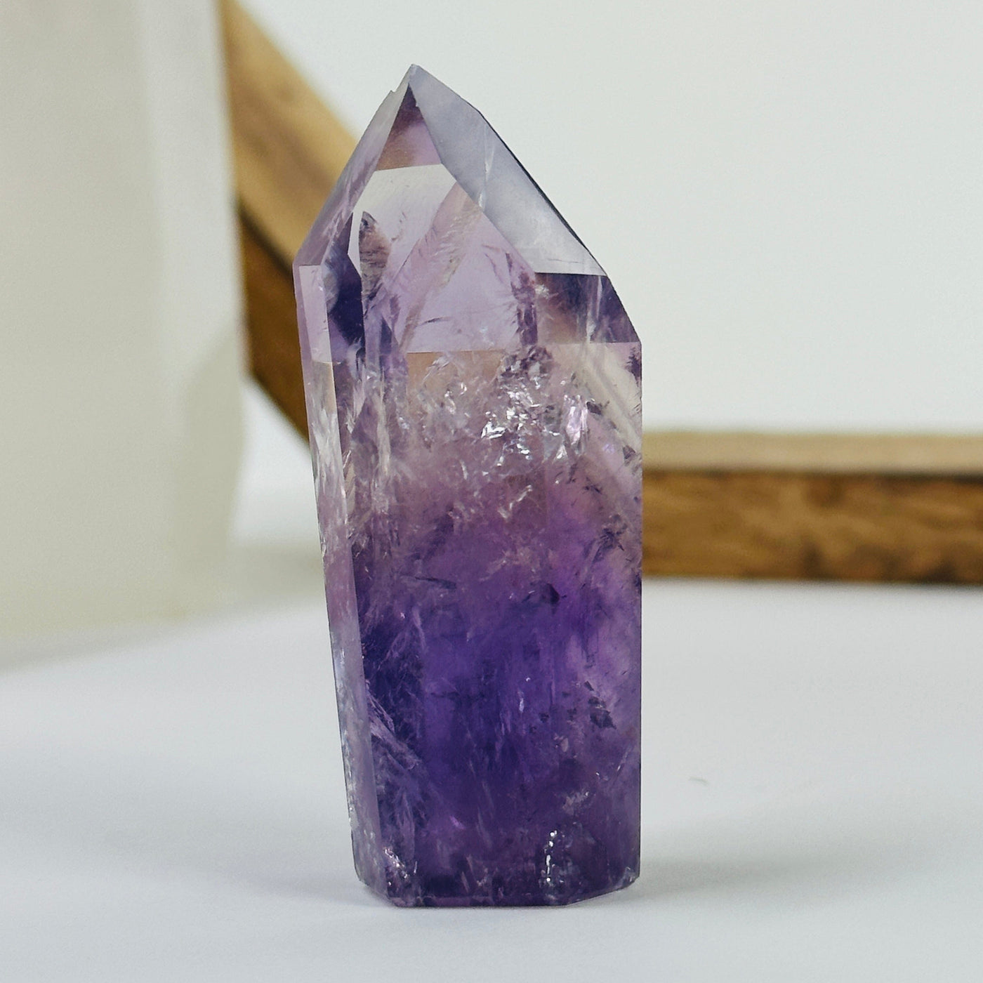 amethyst polished point with decorations in the background