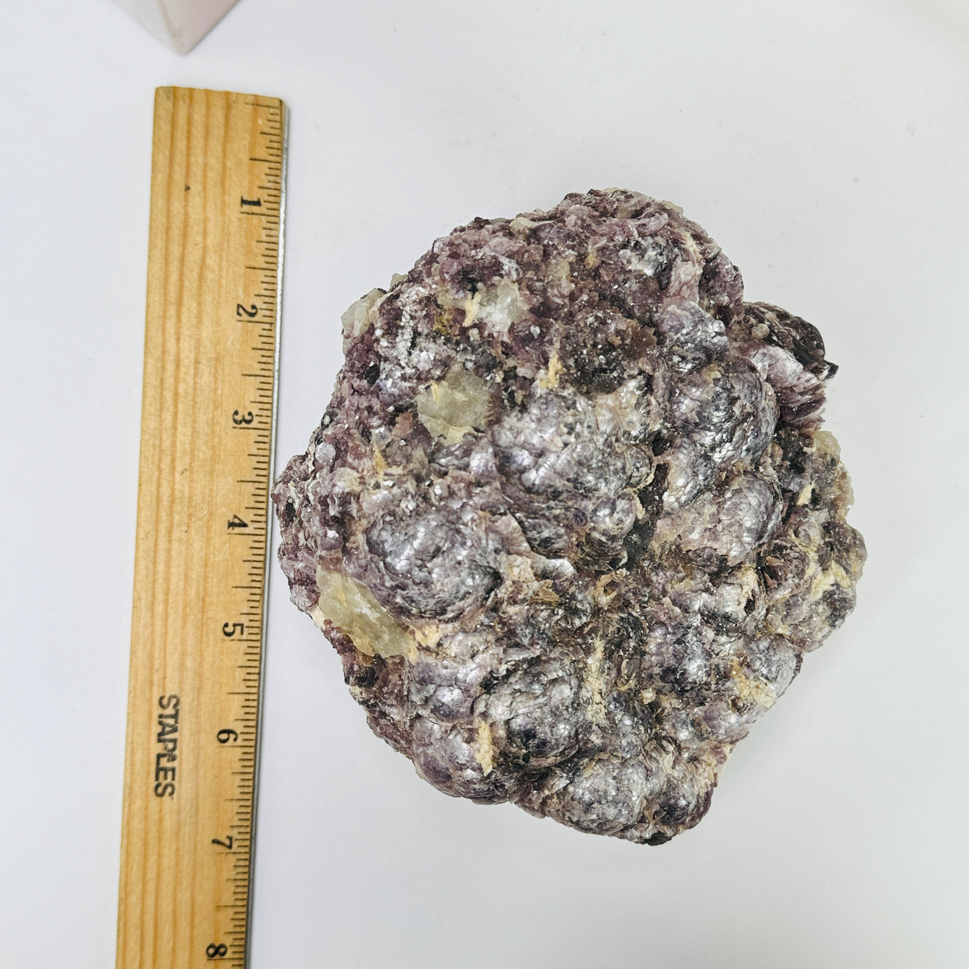 lepidolite next to a ruler for size reference