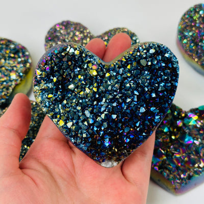 Rainbow titanium heart with decorations in the background