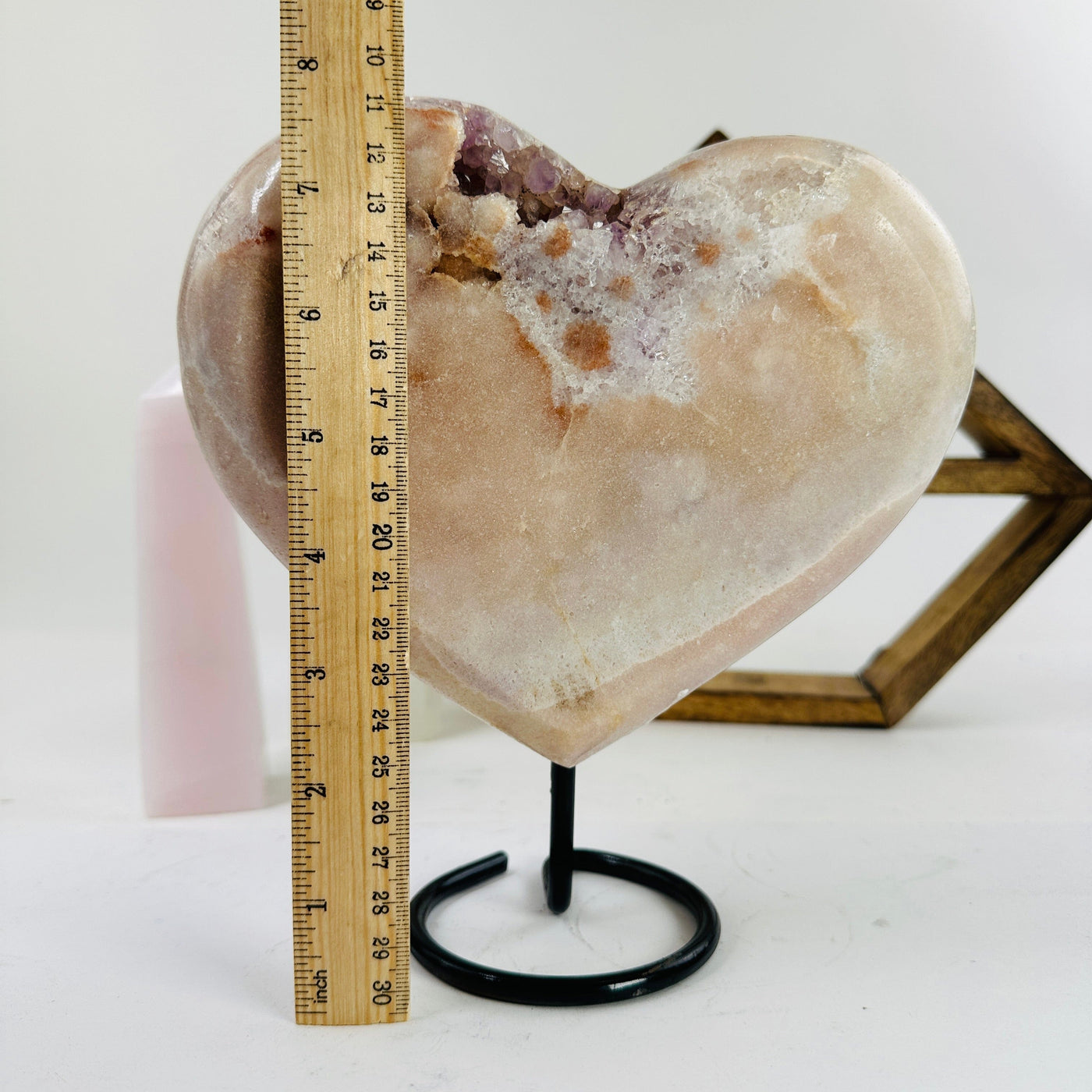 pink amethyst on stand next to a ruler for size reference