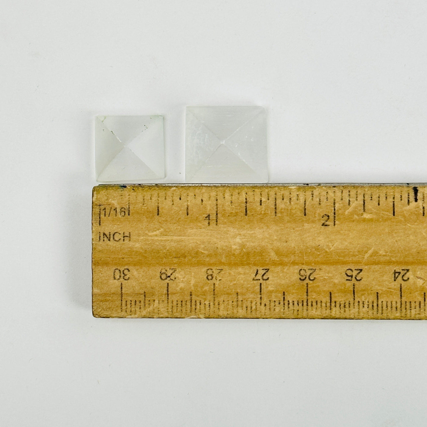 selenite pyramids next to a ruler for size reference