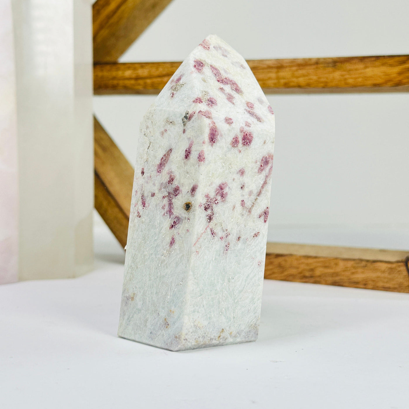 pink tourmaline point with decorations in the background