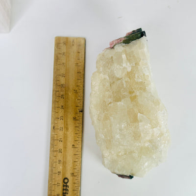 pink tourmaline cluster next to a ruler for size reference