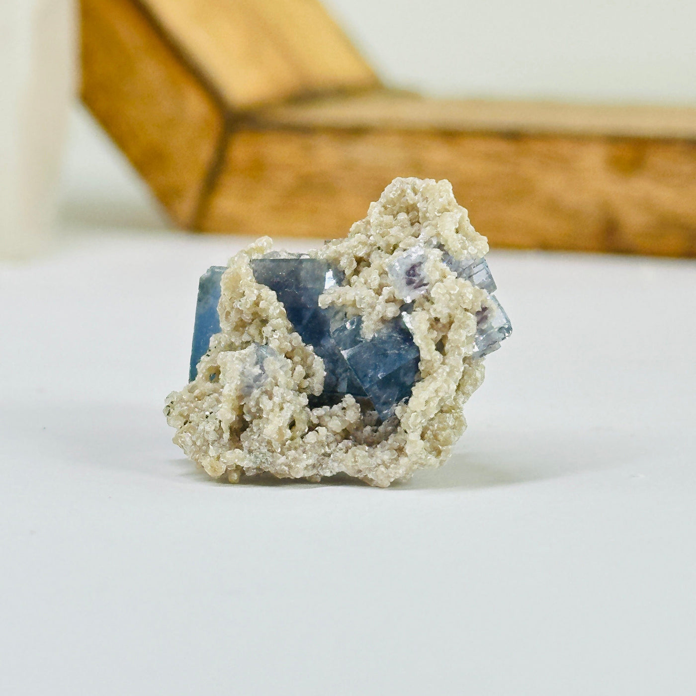 Blue fluorite crystal with decorations in the background