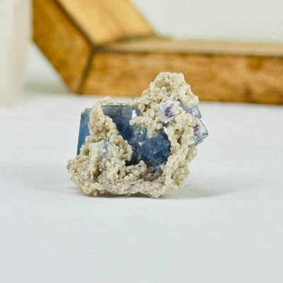 Blue fluorite crystal with decorations in the background