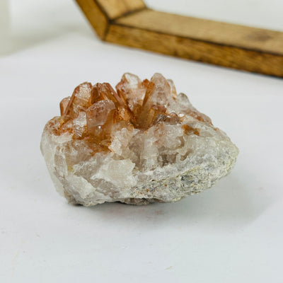 tangerine quartz cluster with decorations in the background