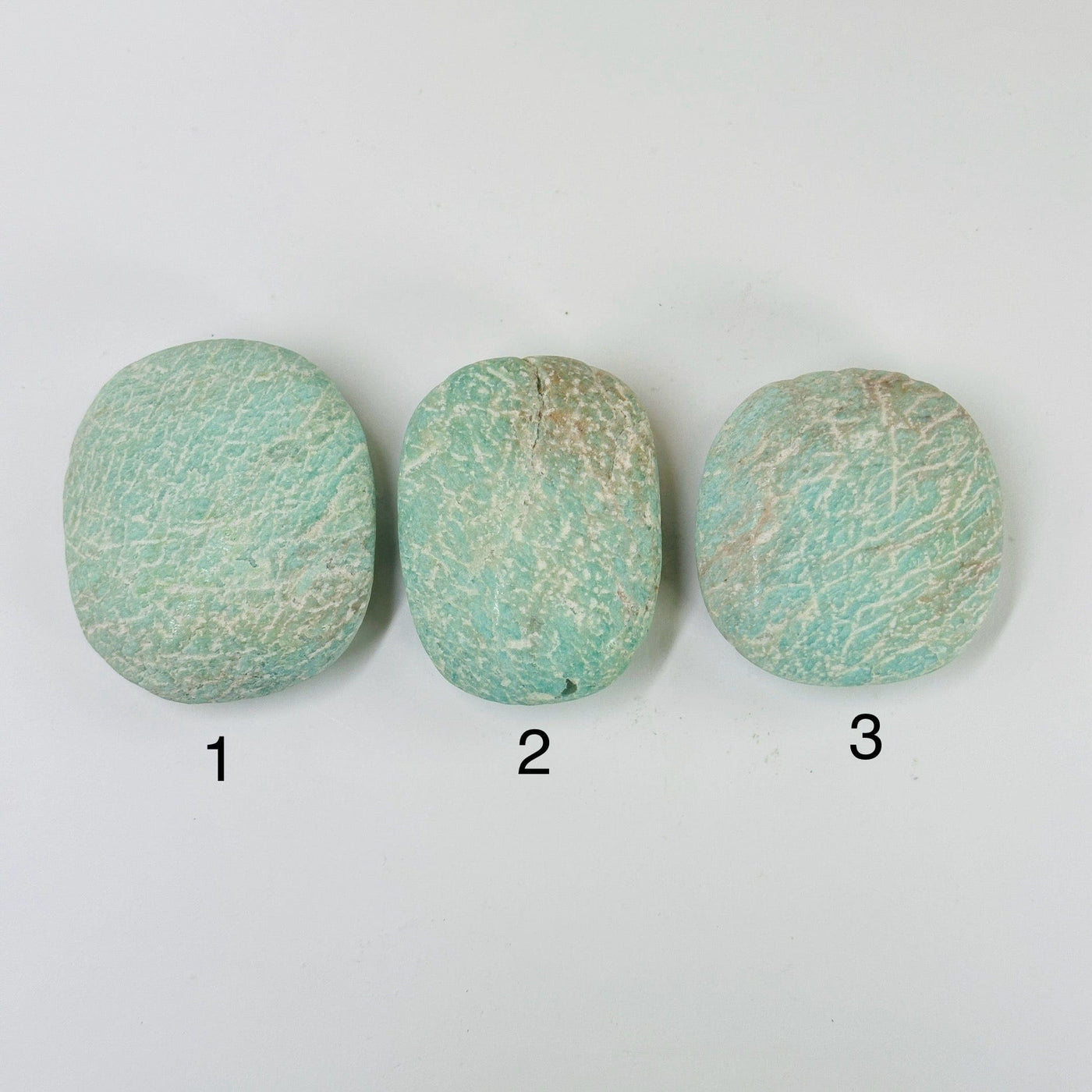 amazonite tumbled stones with decorations in the background