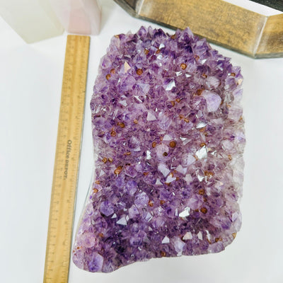 amethyst cluster next to a ruler for size reference