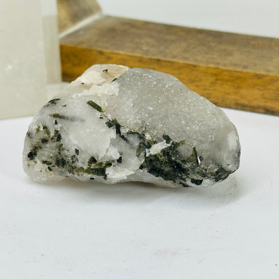 epidote on matrix with decorations in the background