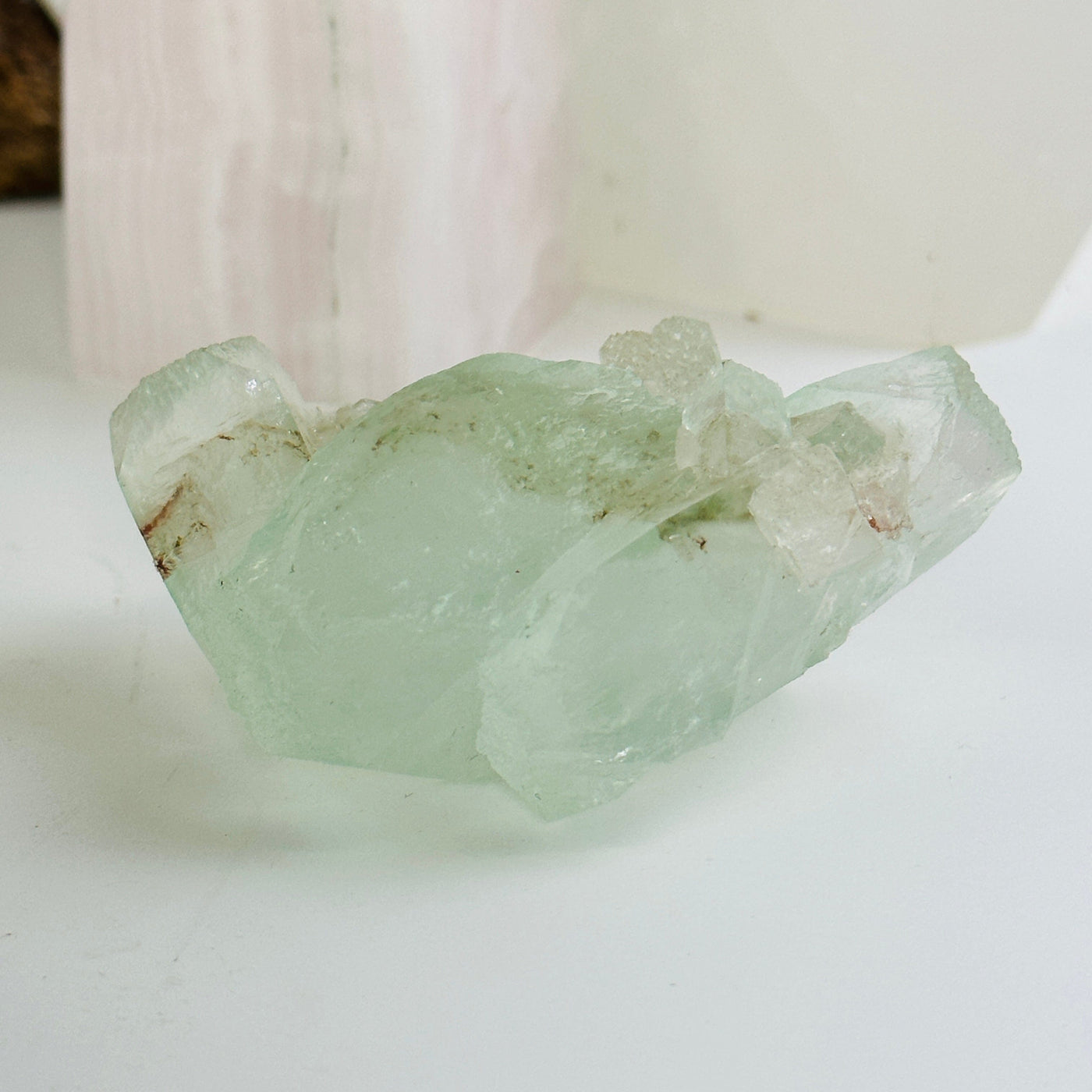 green apophyllite with stilbite cluster with decorations in the background