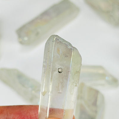 aura quartz crystal with decorations in the background