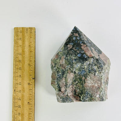 rhyolite semi polished point next to a ruler for size reference