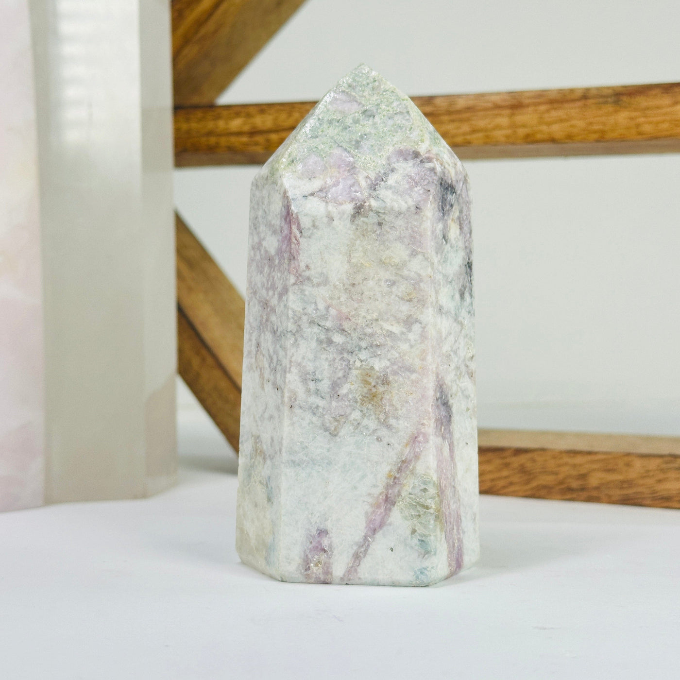 pink tourmaline point with decorations in the background