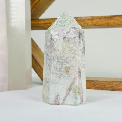 pink tourmaline point with decorations in the background