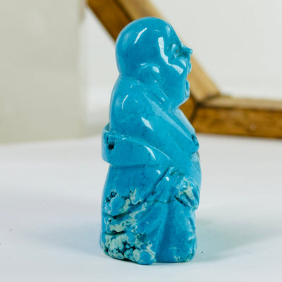 blue howlite buddha statue with decorations in the background