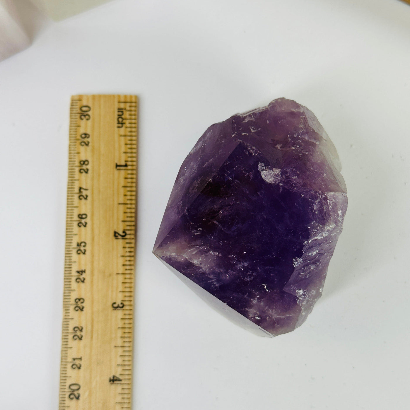 amethyst point next to a ruler for size reference