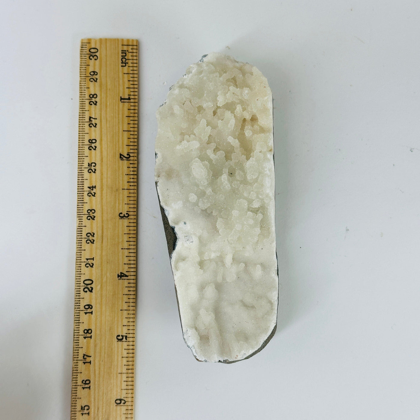 apophyllite on matrix next to a ruler for size reference