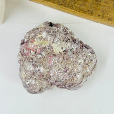 lepidolite cluster with decorations in the background