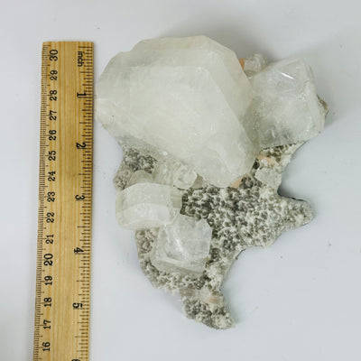 zeolite apophyllite cluster next to a ruler for size reference