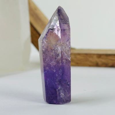 amethyst polished point with decorations in the background